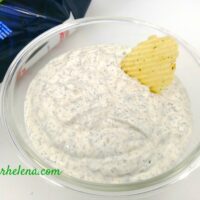 A dill dipping sauce shown in a bowl along with a potato chip. The dill dip recipe is quick and easy to make.