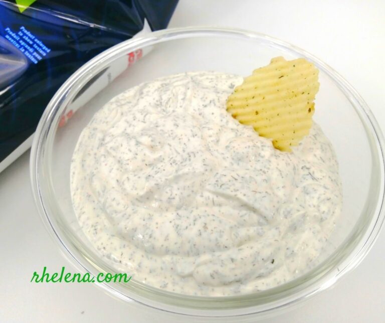A dill dipping sauce shown in a bowl along with a potato chip. The dill dip recipe is quick and easy to make.