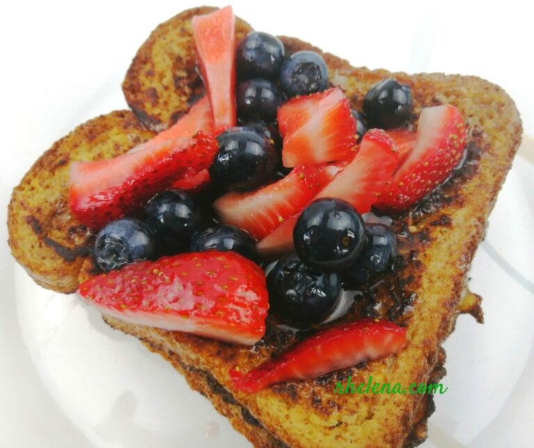 French toast shown with blueberries and strawberries.