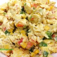 Scrambled eggs with corn, bell peppers and tomato.